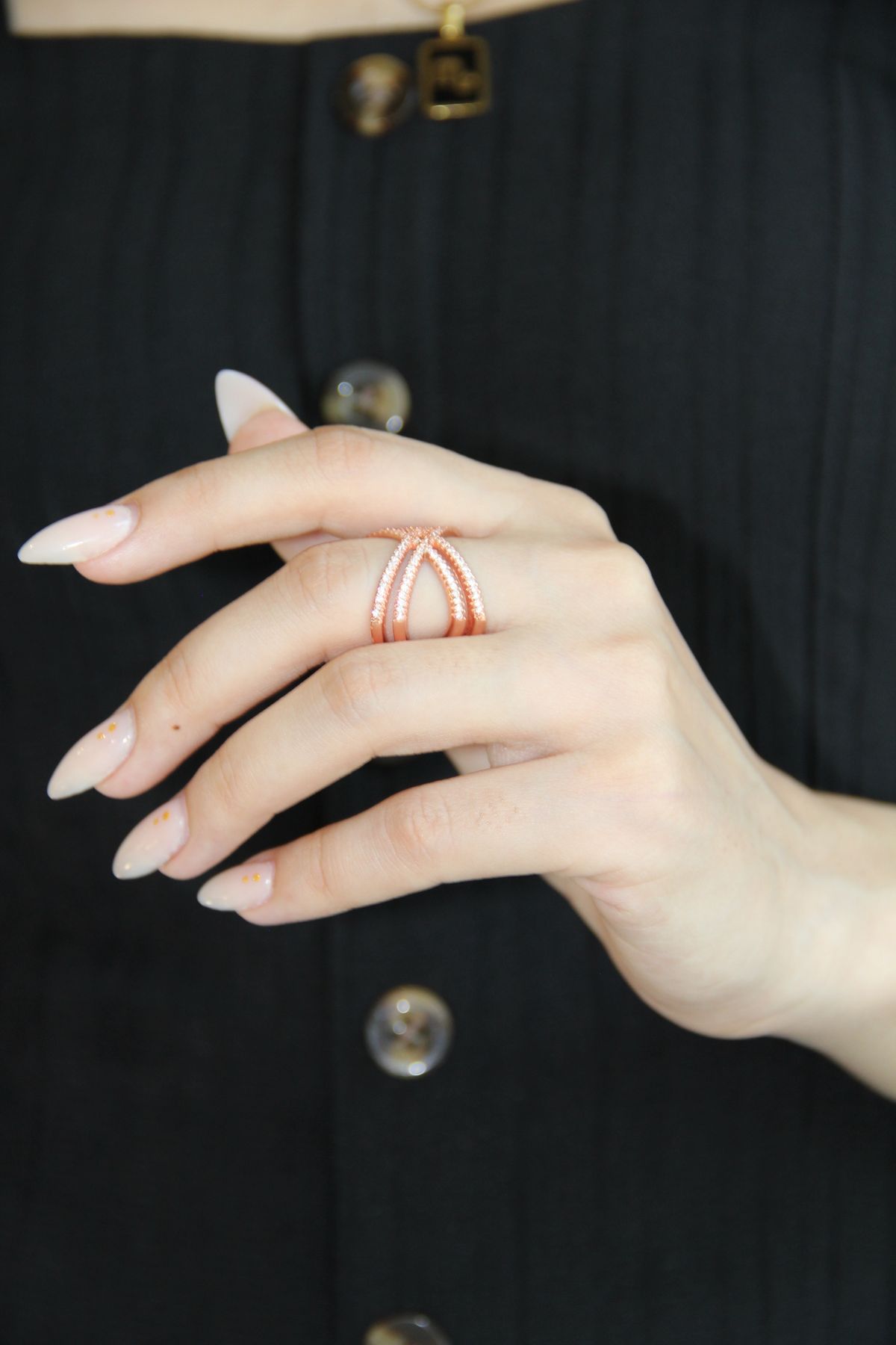 Rose gold crossover ring on a hand